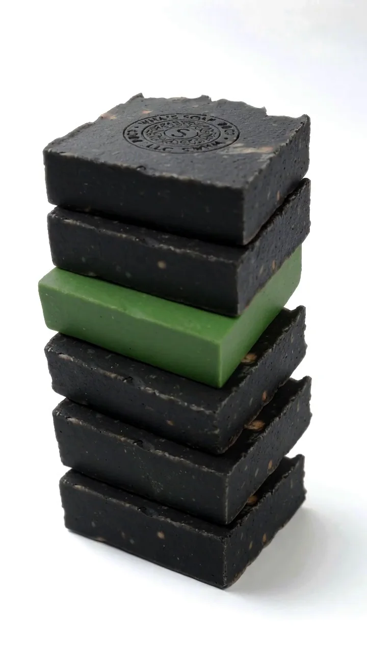 Stapel handgemaakte groene zeep met ingestempeld logo